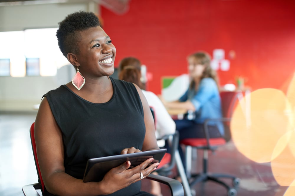 Confident female designer working on a digital tablet in red creative office space-2